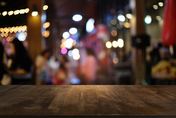 Empty wood table top and blur of night market background/selective focus .For montage product display.