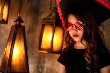 Close-up portrait of child girl in pirate image with reflection red eyeglasses posing in hold of...