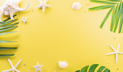 Summer composition concept made from starfish, sea shell and monstera leaf on pastel yellow background.