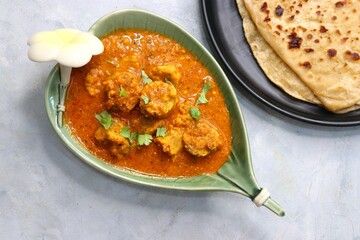 Rajasthani Gatta Curry or Besan Ke Gatte Ki Sabzi. Gatte are gram flour roundels or chickpea flour dumplings are cooked in a spicy, tangy yogurt based curry. delicacy of Rajasthan, India. copy space.