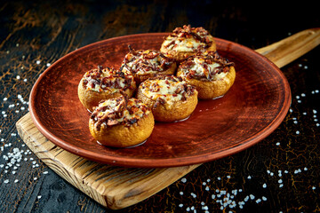 Mushrooms with bacon and cheese baked on the grill in a clay dish. Georgian cuisine
