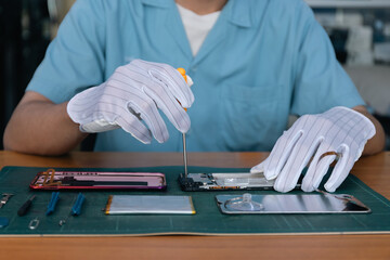 Asian technician repairing smartphone, electronics, repairs, upgrades and technology.