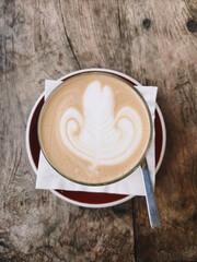 Glass of Caramel Latte with latte art with Wooden Background