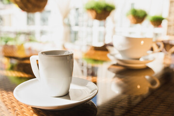 Cups of coffee and tea are on a glass table in the gazebo. Served for tea. table on the summer terrace of the cafe. morning ritual before work day. Rest between work and coffee break