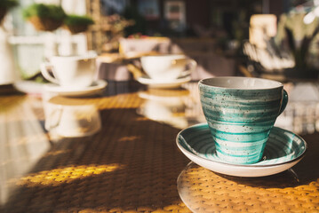 Cups of coffee and tea are on a glass table in the gazebo. Served for tea. table on the summer terrace of the cafe. morning ritual before work day. Rest between work and coffee break