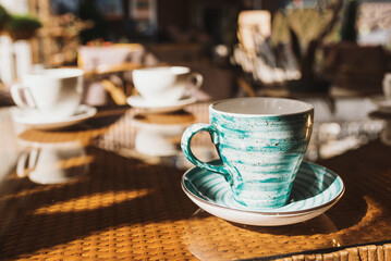 Cups of coffee and tea are on a glass table in the gazebo. Served for tea. table on the summer terrace of the cafe. morning ritual before work day. Rest between work and coffee break