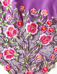 Purple kebaya cloth with intricate embroidery of pink flowers.