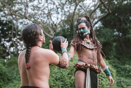 Portrait of two indigenous men with mayan garments and a rubber ball
