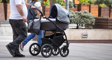 Fototapeta na wymiar Father walking in city baby in stroller.
