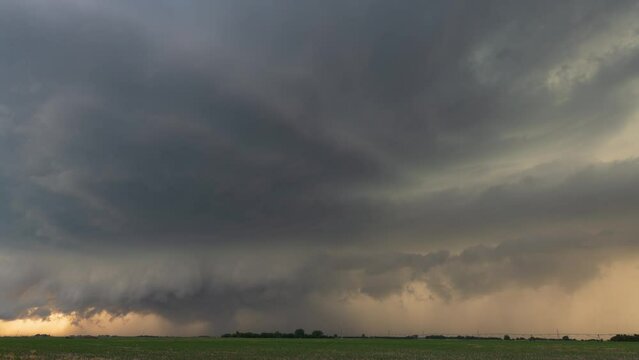 A tornado-warned supercell approaches our position as the sun begins to set, creating an orange tinge to the sky.
