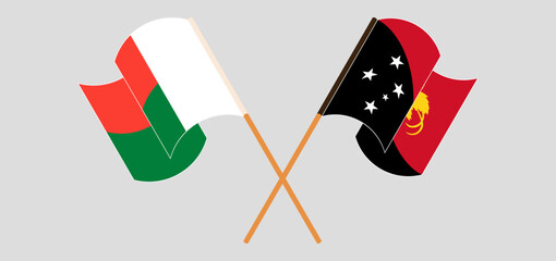 Crossed and waving flags of Madagascar and Papua New Guinea