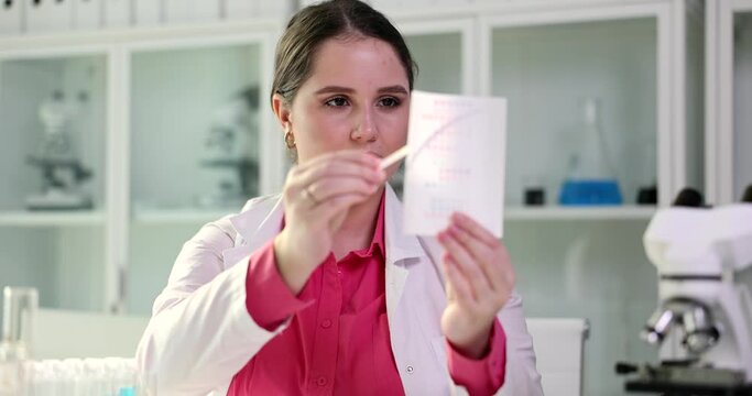 Urine pH test strips and scientist doctor closeup. Doctor doing a test with litmus strips