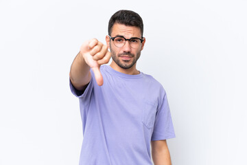 Young caucasian man isolated on white background showing thumb down with negative expression