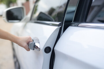 Close-up of a female hand opening a white car door. Automotive concept. opening doors, concept cars, driving safely. theft concept.