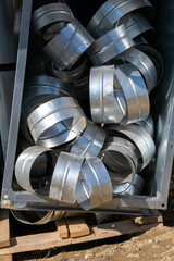 Various sheet metal air ducts in stock for installation. Connecting pipes for air ducts in the box.