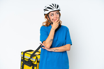 Young caucasian woman with thermal backpack isolated on white background having doubts and with confuse face expression