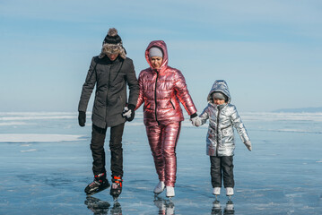 The sport family is skating on the ice of Lake Baikal. Winter Siberian landscape