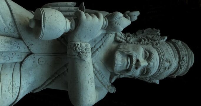 Vertical slow motion dolly shot of a sacred statue at pura tirta empul temple on bali in ubud indonesia