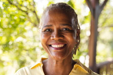 Portrait of happy senior african american woman in sunny nature