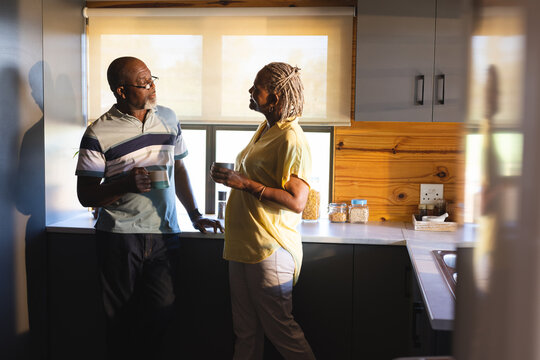 Senior african american couple drinking coffee and talking in kitchen