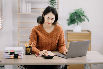 lifestyle of office workers Woman calculating expenses and using laptop. Home office. Work place. Lifestyle.