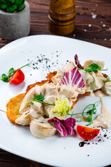 Fototapeta na wymiar Potato pancakes with chicken fillet and mushrooms in cream sauce, tomatoes and lettuce, lunch.