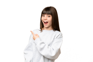 Little girl over isolated green chroma key background surprised and pointing side