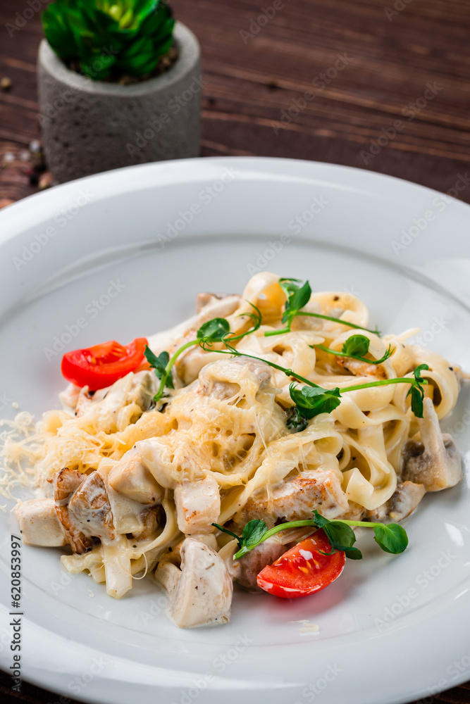 Poster linguini pasta with chicken fillet, mushrooms, cheese, cream sauce, tomatoes and herbs, italian dinn