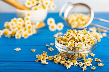 Dried chamomile tea in a bowl on a texture table.dry chamomile. Chamomile tea. flat lay. Composition with a bouquet and chamomile inflorescences in a mortar. Herbal drink. Soothing and tonic tea. 