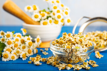 Dried chamomile tea in a bowl on a texture table.dry chamomile. Chamomile tea. flat lay....