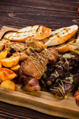 Fried chicken, beef and pork fillet with potato wedges, peppers, cherry tomatoes and sauce.