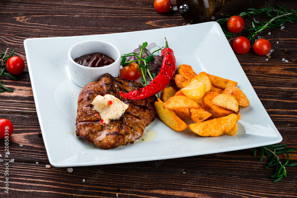 Canvas Prints fried pork fillet steak with rustic fried potato wedges, onions, chili peppers, cherry tomatoes and 