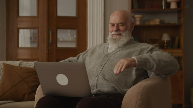 Satisfied Senior Man Reading on Laptop, Happy Elderly Person