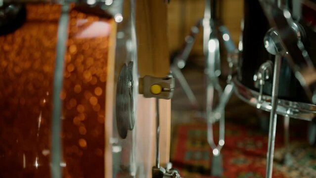 man's foot pressing bass drum pedal in recording studio drummer drumming indoors close-up