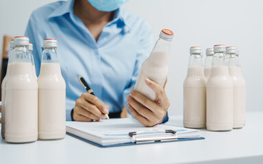 Expert control quality milk factory worker checking milk bottle quality control procedure, Dairy factory industry products. Purchasing Department