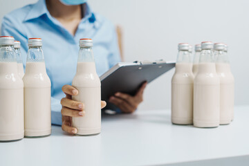 Expert control quality milk factory worker checking milk bottle quality control procedure, Dairy factory industry products. Purchasing Department