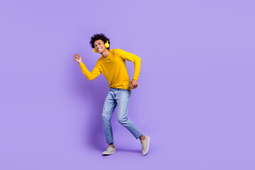 Full size photo of good mood handsome guy dressed yellow long sleeve headphones dancing enjoy music isolated on purple color background