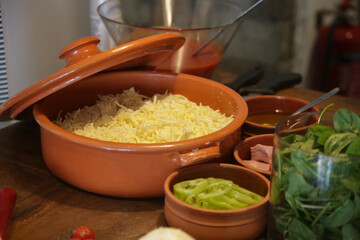 Grated cheese and another pizza ingredient prepared and served in bowls