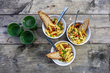 Stockholm, Sweden A dinner for three of pasta bowls with peas, bread and corn.