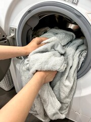 clean linen, female hands take out clean linen from the washing machine