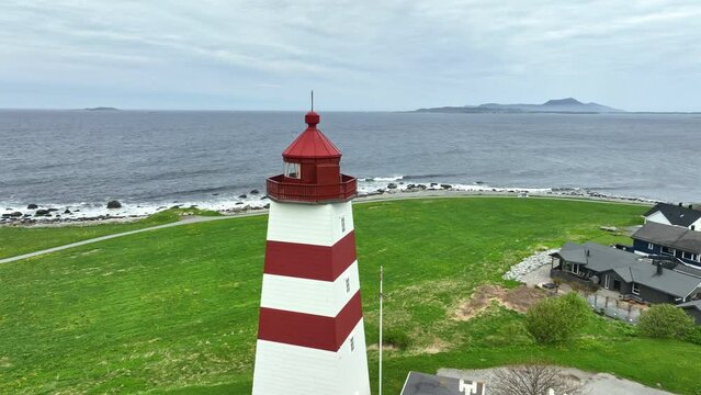 Alnes lighthouse outside Alesund Norway - Flying and rotating closely around top of lighthouse with Atlantic Ocean and horizon seen in background