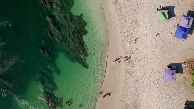 Scenic Rocky Beach Shore With Tourists On Sand At Playa Conchal, Costa Rica, 4K Drone Flyover