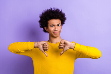 Photo of strict young funny unsatisfied guy dislike thumbs down gesture demonstrate his bad rating isolated on purple color background © deagreez