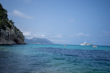 Widok na nabrzeże Wyspy Sardynia, niebieskie niebo i białe jachty 
