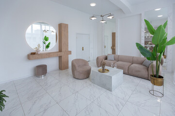 living room with soft beige furniture in a light luxury interior design of a modern apartment in a minimalist style with marble trim and huge windows. daylight inside.