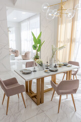 stylish kitchen and a set dining table in a light luxury interior design of a modern apartment in a minimalist style with marble trim and huge windows. daylight inside.