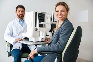 Woman happy with result after checking eyesight in ophthalmology clinic  - obrazy, fototapety, plakaty
