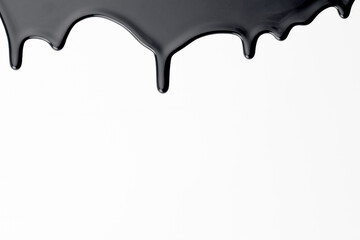 Paint drops flowing down on white paper. Black ink blots abstract background