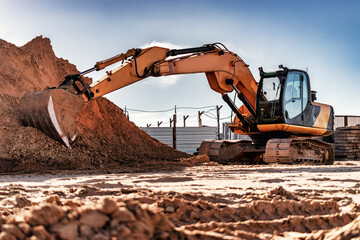 Crawler excavator with bucket pulled forward at a construction site. Close-up of a powerful excavator. Rental of construction equipment. Earthworks contractor. © Anoo