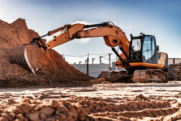 Crawler excavator with bucket pulled forward at a construction site. Close-up of a powerful...